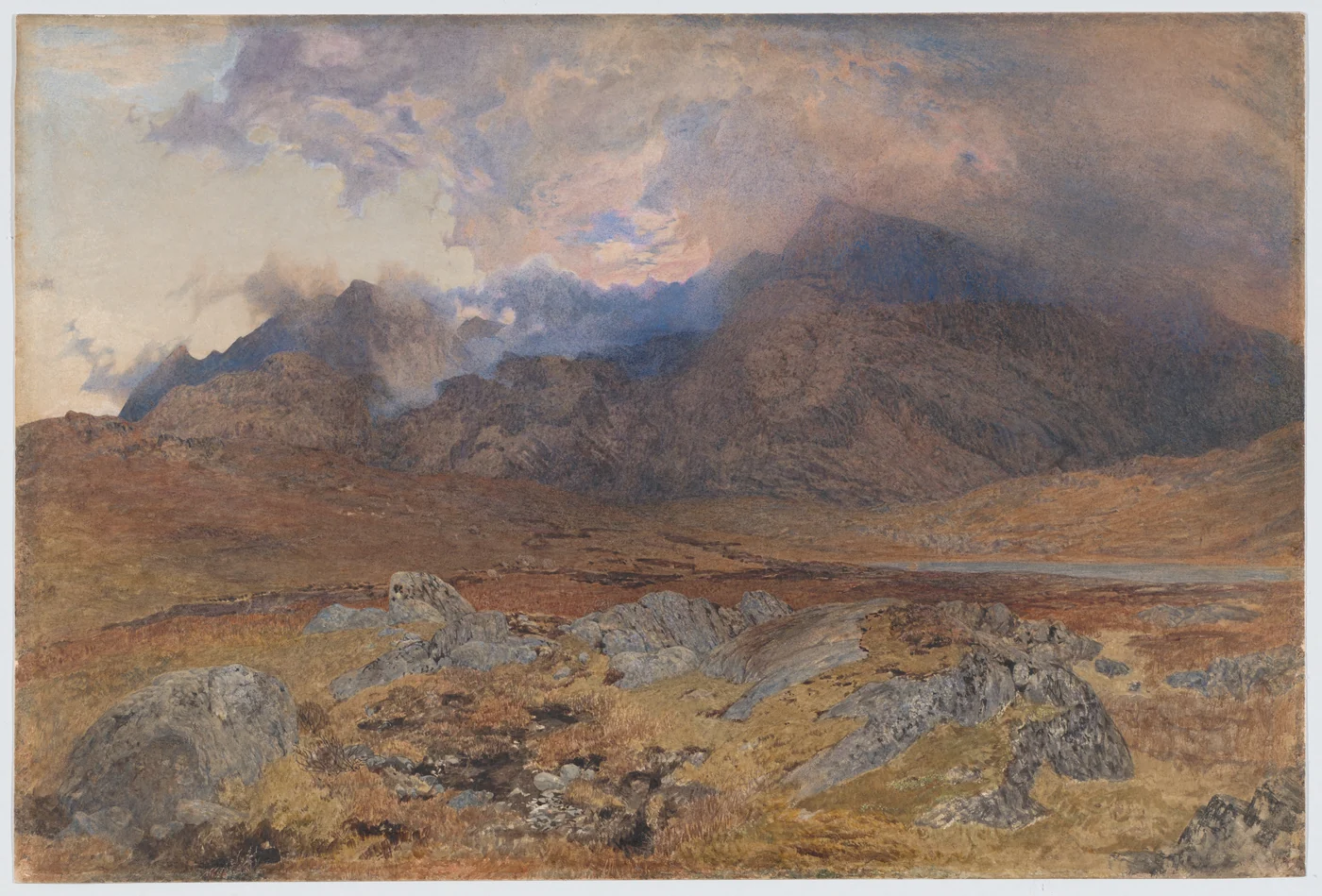 Hunt’s Snowdon landscape with rocky foreground, distant mountains, and dark clouds opening toward light.